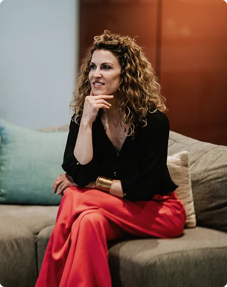 Joanna on a couch in red pants